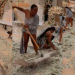 Lady uses broom to sweep $50, $100 bills sprayed at wedding party