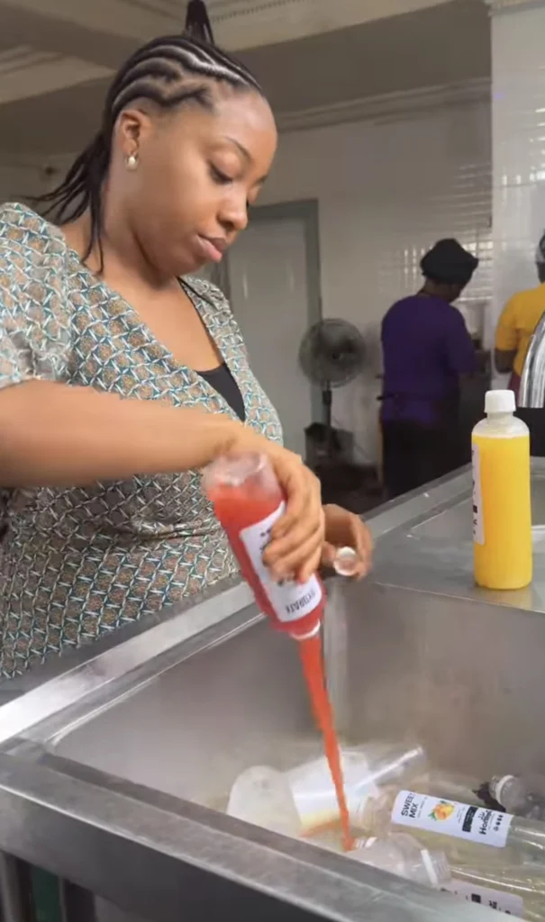 Nigerian business woman dispose several bottles of fruit juice after it got spoilt because of lack of electricity 